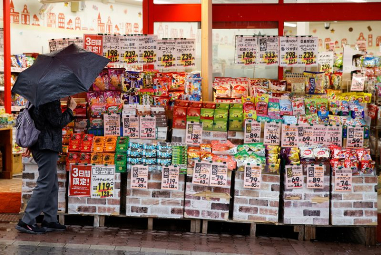 Une femme regarde des articles dans un magasin à Tokyo