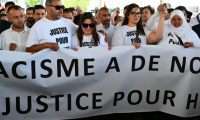 Les proches de Hichem - les cousins Mouna (droite) et Siam Mouraoui, ainsi que des participants, tiennent une banderole  lors d'une marche blanche en hommage à Hichem Miraoui à Marseille le 8 juin 2025 ( AFP / Christophe SIMON )