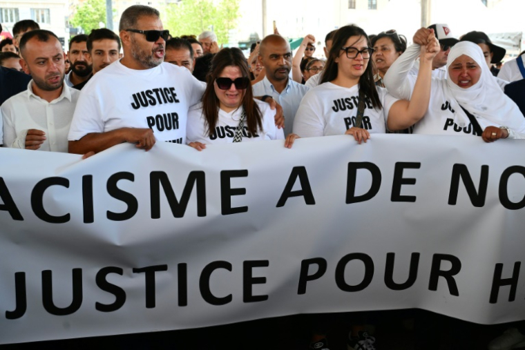 Les proches de Hichem - les cousins Mouna (droite) et Siam Mouraoui, ainsi que des participants, tiennent une banderole  lors d'une marche blanche en hommage à Hichem Miraoui à Marseille le 8 juin 2025 ( AFP / Christophe SIMON )
