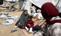 Une famille palestinienne déplacée, dont des membres ont été blessés lors de frappes israéliennes, devant sa tente à Deir el-Balah, dans le centre de la bande de Gaza, le 13 avril 2025 ( AFP / Eyad BABA )