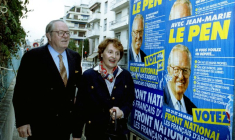 L'ancien leader du Front national, Jean Marie Le Pen, passe devant des affiches électorales du Front national