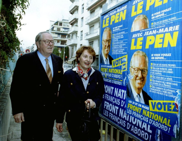 L'ancien leader du Front national, Jean Marie Le Pen, passe devant des affiches électorales du Front national