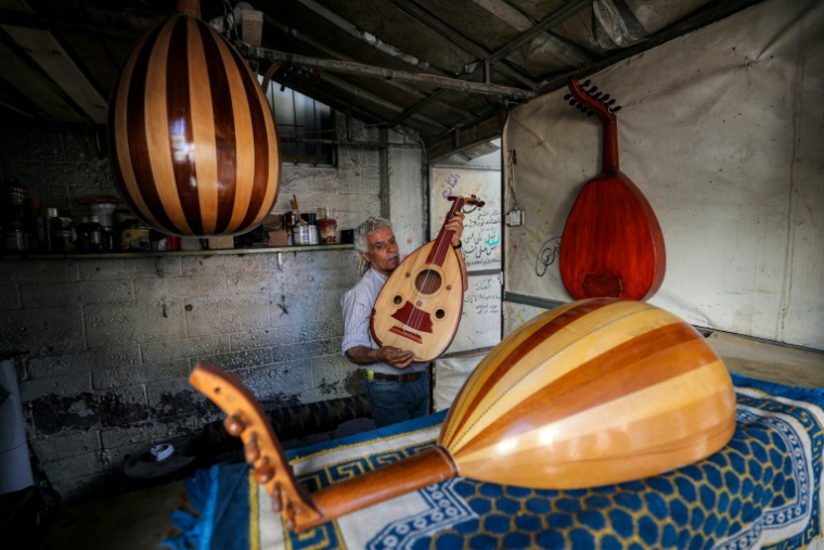 Le luthier palestinien Souhail Abou Chawich dans son atelier de réparation d'ouds, au camp de réfugiés de Nousseirat, dans le centre de la bande de Gaza, le 23 juin 2026 ( AFP / Eyad Baba )