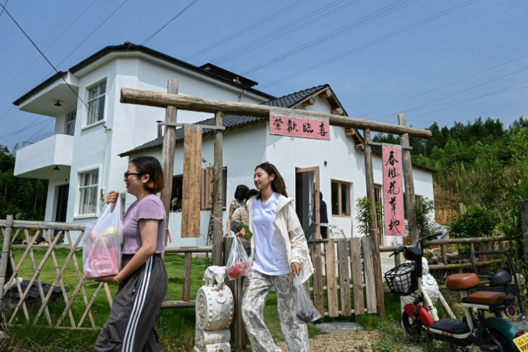 Chen Yani (c), fondatrice du lieu "L'Univers imaginaire de Keke", avec des participantes devant son gîte rural, le 15 juillet 2025 à hangzhou dans la province du Zhejiang, dans l'est de la Chine ( AFP / Jade GAO )