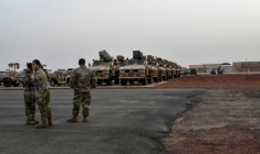 Des soldats américains devant des véhicules militaires prêts à embarquer à bord d'un avion cargo à Niamey, le 7 juin 2024, lors de la cérémonie du premier départ des troupes américaines du Niger ( AFP / BOUREIMA HAMA )