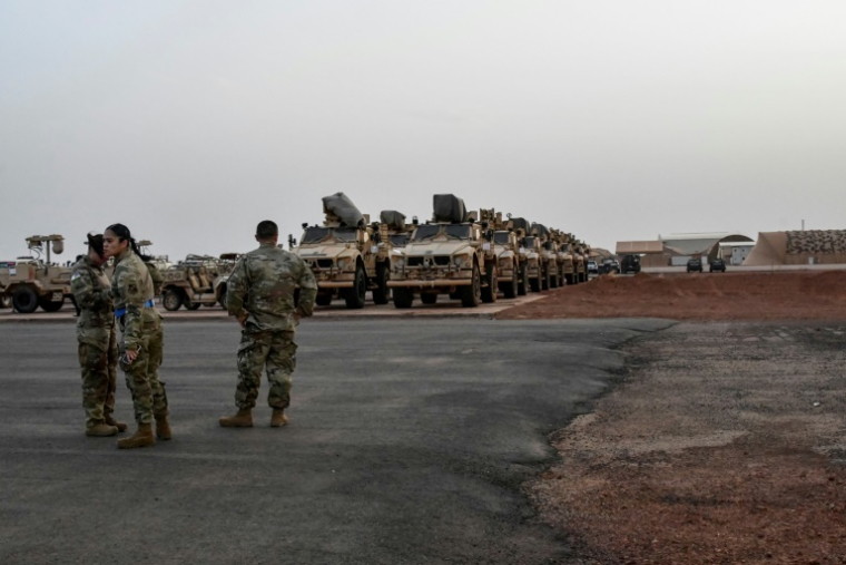 Des soldats américains devant des véhicules militaires prêts à embarquer à bord d'un avion cargo à Niamey, le 7 juin 2024, lors de la cérémonie du premier départ des troupes américaines du Niger ( AFP / BOUREIMA HAMA )