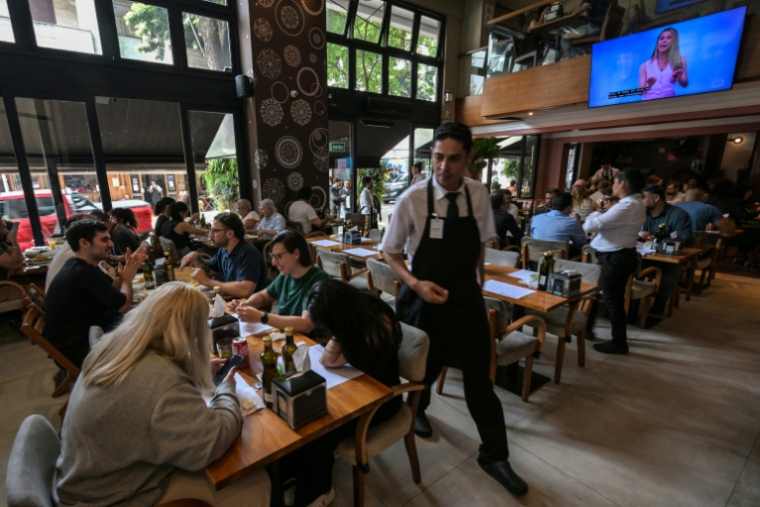 Des personnes déjeunent dans un restaurant à Sao Paulo, le 3 octobre 2025 au Brésil ( AFP / Nelson ALMEIDA )