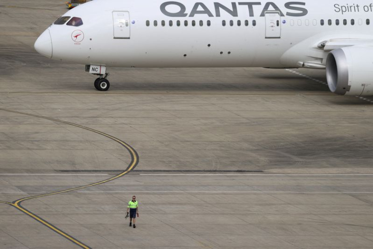 Photo d'archives d'un employé qui marche près d'un avion Qantas à l'aéroport de Sydney, en Australie