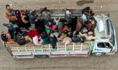 Vue aérienne de membres de la communauté bédouine en cours d'évacuation, à bord d'un camion circulant sur une route à Taarah, dans la province de Soueida, au sud de la Syrie, en direction de Deraa, le 21 juillet 2025 ( AFP / Rami al SAYED )