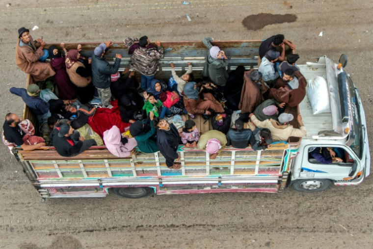 Vue aérienne de membres de la communauté bédouine en cours d'évacuation, à bord d'un camion circulant sur une route à Taarah, dans la province de Soueida, au sud de la Syrie, en direction de Deraa, le 21 juillet 2025 ( AFP / Rami al SAYED )