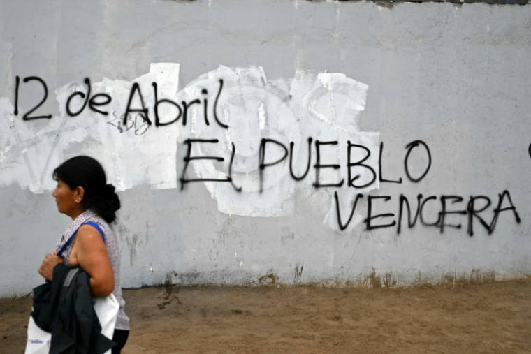 Une femme passe devant une affiche faisant référence à la date de l’élection présidentielle et des législatives au Pérou, un pays où le vote est obligatoire et qui a connu huit présidents depuis 2016 ( AFP / Luis ROBAYO )