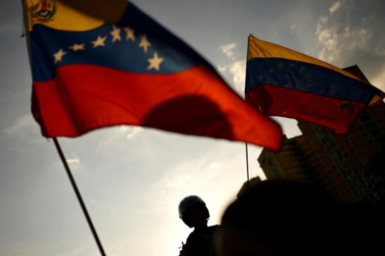 Une partisane de la dirigeante de l’opposition vénézuélienne et lauréate du prix Nobel de la paix Maria Corina Machado agite un drapeau vénézuélien après son arrivée à Caracas, le 25 octobre 2026. Machado est rentrée dans son pays natal le 25 octobre 2026, après près d’un an d’exil, saluant des partisans en liesse dans une église de la ville de Barquisimeto. ( AFP / Maxwell BRICENO )