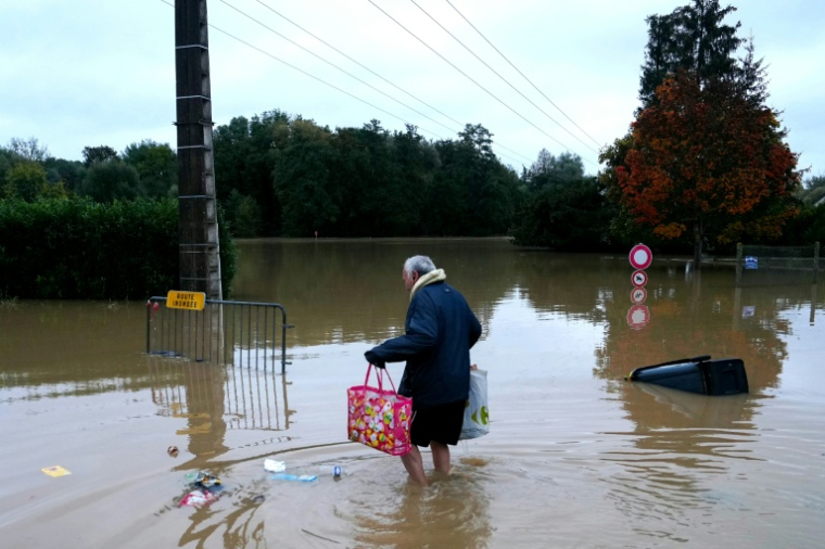 Un habitant se déplace à pied dans une rue inondée de Pommeuse, en Seine-et-Marne, le 10 octobre 2014, après un épidode de fortes pluies ( AFP / Dimitar DILKOFF )