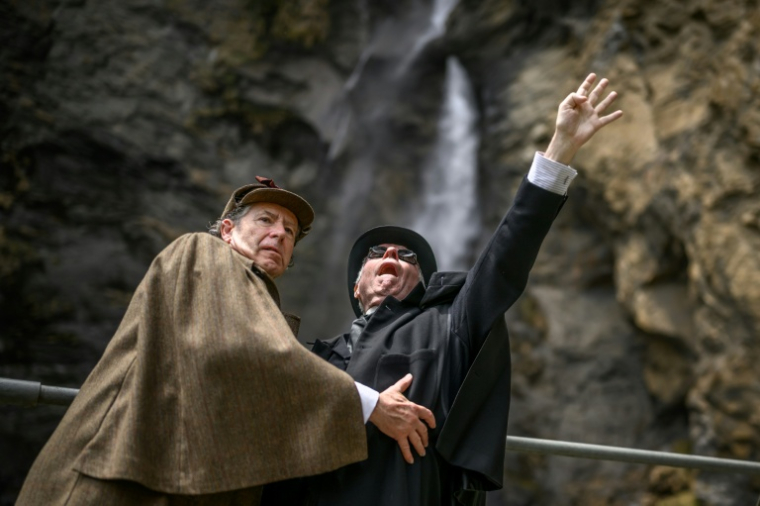 Peter Horrocks (d), vêtu en professeur Moriarty, et Philip Porter, incarnant Sherlock Holmes, aux chutes de Reichenbach, en Suisse, le 3 mai 2026 ( AFP / Fabrice COFFRINI )