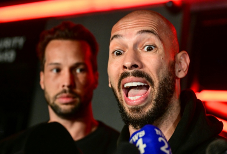 L'influenceur masculiniste Andrew Tate (à droite) et son frère Tristan, le 22 mars 2025 à Bucarest ( AFP / Daniel MIHAILESCU )