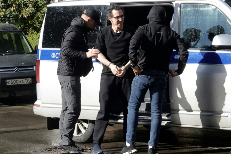 Laurent Vinatier (c) est escorté vers un tribunal à Moscou, le 25 août 2025 ( AFP / TATYANA MAKEYEVA )