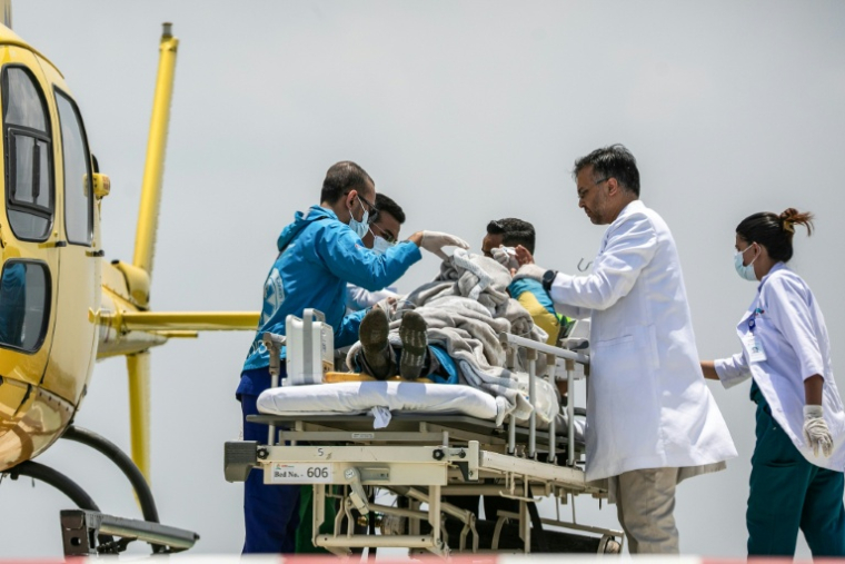 Les secouristes et le personnel médical transfèrent le guide Dawa Sherpa à son arrivée à l'hôpital de Katmandou le 4 juin 2026 ( AFP / PRABIN RANABHAT )