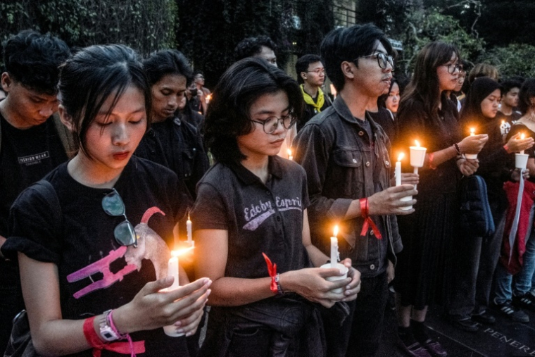 Des étudiants tiennent des bougies à l'Institut de Technologie de Bandung (ITB) dans la ville de Bandung, Java occidental, le 2 septembre 2025, en hommage aux victimes tuées lors d'un affrontement entre la police et des manifestants exigeant une réforme de la police et la dissolution du Parlement ( AFP / Timur Matahari )