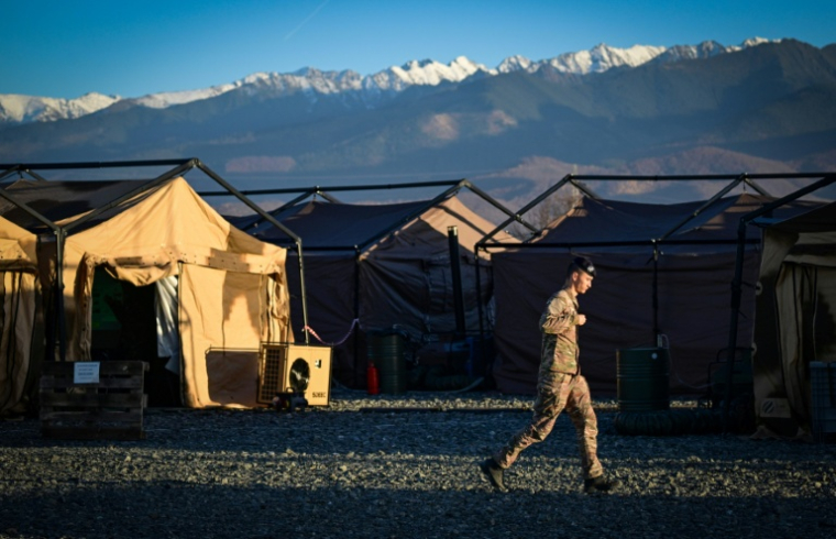 Un militaire français passe devant des tentes lors de l'exercice militaire "Dacian Fall" de l'Otan au centre logistique de Cărșișoara, le 2 novembre 2025 en Roumanie ( AFP / Daniel MIHAILESCU )