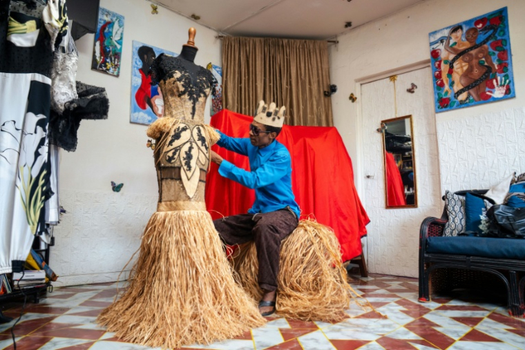 Le créateur de mode gabonais Chouchou Lazare fait les derniers ajustements à une robe en raphia dans son atelier à Libreville, le 9 février 2026 ( AFP / Nao Mukadi )