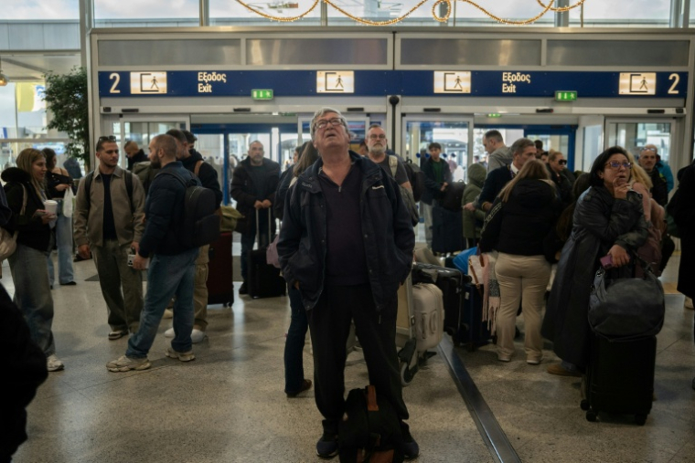 Des voyageurs attendent à l'aéroport d'Athènes-Spata après des retards et des reports de vols dans le pays dus à un "problème technique", le 4 janvier 2026 ( AFP / Angelos TZORTZINIS )