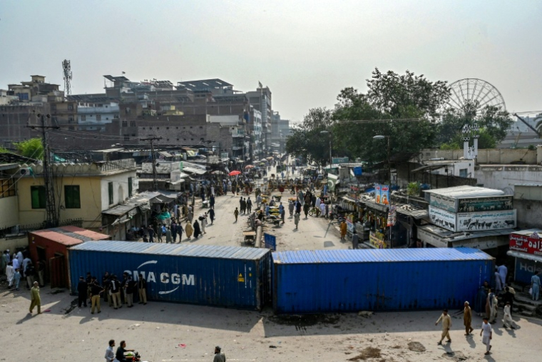 Une route bloquée par des conteneurs maritimes à Peshawar, la capitale de la province pakistanaise de Khyber Pakhtunkhwa où des milliers de partisans de l'ex-Premier ministre emprisonné Imran Khan défilent pour exiger sa libération, le 11 octobre 2026 ( AFP / Abdul MAJEED )
