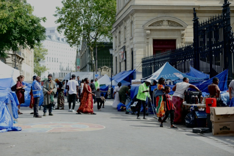 Des migrants et des tentes de fortune installées en plein centre de Paris le 21 août 2026 ( AFP / Thomas SAMSON )