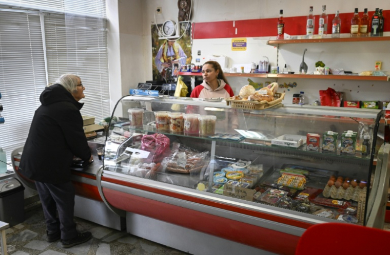 Une cliente fait ses courses dans une épicerie du village de Chuprene, le 7 décembre 2025 en Bulgarie ( AFP / Nikolay DOYCHINOV )
