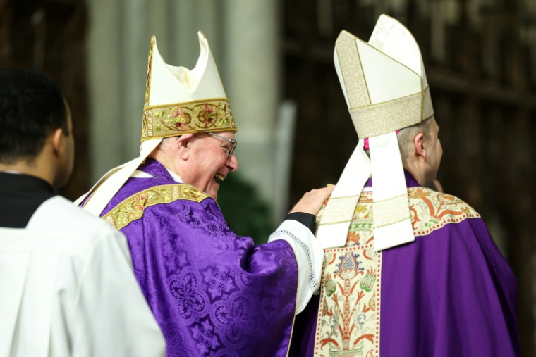 Le cardinal Timothy Dolan (gauche) et son successeur à la tête de l'archidiocèse de New York, Mgr Ronald Hicks, lors d'une messeen la cathédrale Saint-Patrick à New York le 18 décembre 2025 ( AFP / CHARLY TRIBALLEAU )