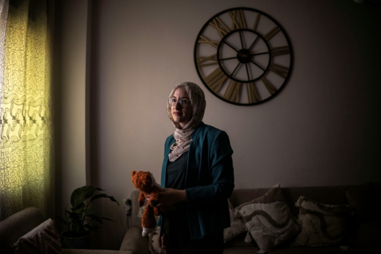 Dania Abu Haikal, la mère de Sam, tué à 7 mois par un soldat israélien alors qu'il se trouvait sur ses genoux, tient la peluche de son fils, à Bethléem, en Cisjordanie occupée, le 7 août 2026 ( AFP / JOHN WESSELS )