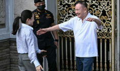 L'ancien Premier ministre Thaksin Shinawatra salue sa fille Paetongtarn Shinawatra à sa sortie de prison, le 11 mai 2026 à Bangkok ( AFP / Lillian SUWANRUMPHA )