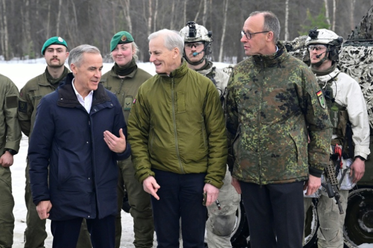 De gauche à droite le Premier ministre canadien Mark Carney, le Premier ministre norvégien Jonas Gahr Støre et le chancelier allemand Friedrich Merz, à la base aérienne de Bardufoss, en Norvège, le 13 mars 2026 ( AFP / John MACDOUGALL )