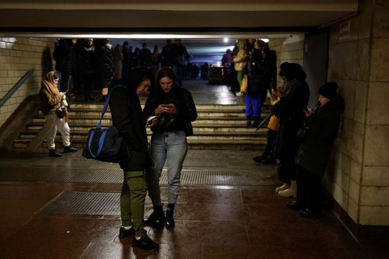 Des personnes près d'une station de métro après que des infrastructures civiles essentielles aient été touchées par des attaques de missiles russes, à Kiev