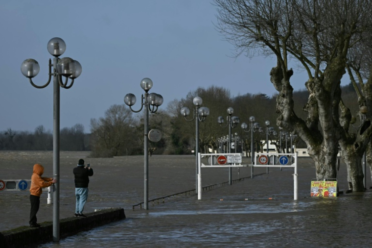 Des badauds regardent la Garonne en crue à La Réole (Gironde)le 12 février 2026 ( AFP / PHILIPPE LOPEZ )