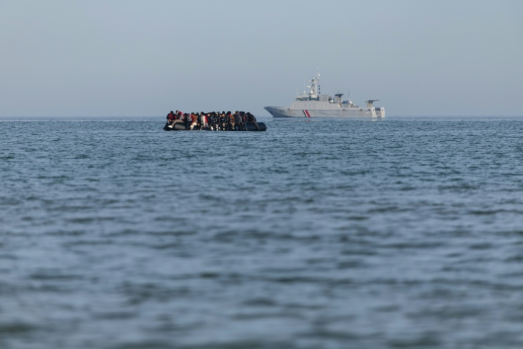 Des migrants à bord d'un bateau de passeurs passent devant un navire de la gendarmerie française alors qu'ils tentent de traverser la Manche, au large de la plage de Gravelines, dans le nord de la France, le 3 mars 2026 ( AFP / Sameer Al-DOUMY )