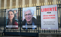 Les photos de Cécile Kohler et Jacques Paris sur les grilles de l'Assemblée nationale à Paris le 25 mars 2025 ( AFP / BERTRAND GUAY )