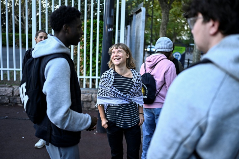 La militante écologiste suédoise Greta Thunberg parle avec des élèves devant le lycée Paul-Eluard à Saint-Denis, en Seine-Saint-Denis, le 13 octobre 2026 ( AFP / JULIEN DE ROSA )