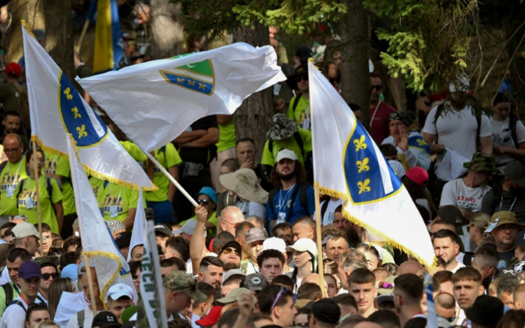 Les participants agitent leurs drapeaux à Nezuk, village dans l'est de la Bosnie, au départ de la "marche pour la paix" qui commémore les 30 ans du massacre de Srebrenica, le 8 juillet 2025 ( AFP / ELVIS BARUKCIC )