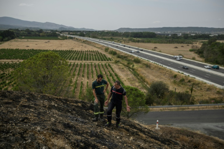 Stéphane Paoli (g), technicien de l'ONF, et Jean-Paul Baylac, chef du service des incendies de forêt du Service d'incendie et de secours de l'Aude, inspectent une zone touchée par un récent incendie de forêt, à Luc-sur-Orbieu, près de Narbonne, le 19 août 2025 ( AFP / Ed JONES )