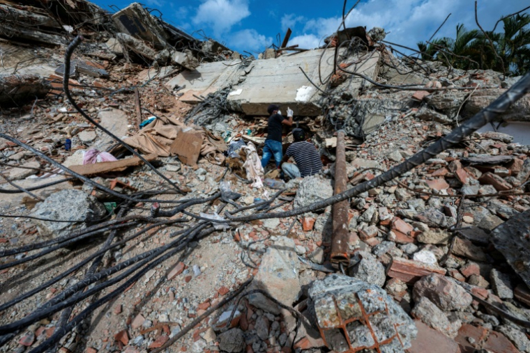 Cette photo prise le 2 juillet 2026 à Caraballeda, dans l'État de La Guaira, montre des bénévoles recherchant des survivants dans un immeuble effondré après le double séisme du 24 juin ( POOL / Miguel MEDINA )