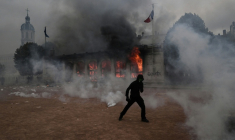 Un protestataire devant l'Office de tourisme incendié lors d'une manifestation contre la vie chère à Lyon, le 17 octobre 206 ( AFP / JEFF PACHOUD )