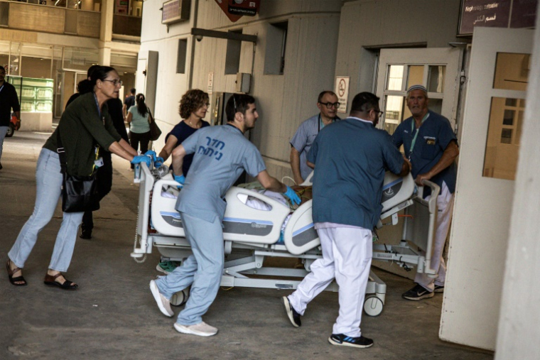 Des médecins évacuent un patient d'un bâtiment de l'hôpital Soroka à Beersheva, dans le sud d'Israël, après une attaque de missiles iraniens, le 19 juin 2025 ( AFP / JOHN WESSELS )
