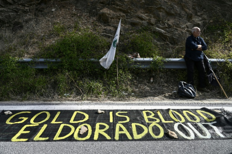 Un manifestantà côté d'une banderole lors d'une manifestation en marge de l'inauguration de la mine d'or et de cuivre de Skouries, dans la péninsule de Chalcidique, dans le nord de la Grèce, le 8 octobre 2026 ( AFP / Sakis Mitrolidis )
