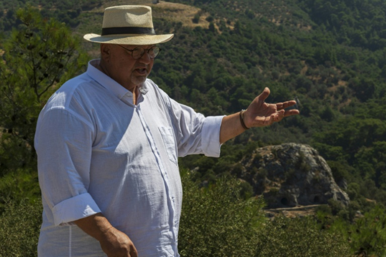 Altan Altin, historien ayant longuement étudié le lien entre Homère et Izmir, présente les grottes d'Homère à Bornova, le 7 août 2026 en Turquie ( AFP / Ahmet Ayberk Cimen )