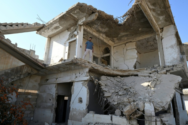 Le Syrien Ammar Ziadeh devant les ruines de la maison d'où est sorti le numéro zéro du média indépendant Enab Baladi qu'il a co-fondé. Daraya, le 10 novembre 2025 ( AFP / LOUAI BESHARA )