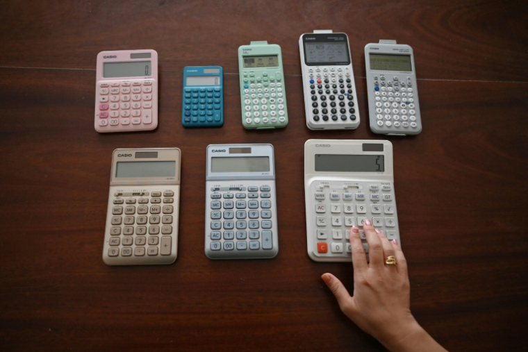 Une employée de Casio présente des calculettes de la marque au musée Toshio Kashio de Tokyo, le 25 novembre 2025  ( AFP / GREG BAKER )