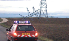 une voiture des sapeurs pompiers de Truchtersheim passe ,le 26 décembre 1999, devant les pylônes d'une ligne haute tension de 20 000 volts abattus par le vent ( AFP / DAMIEN MEYER )