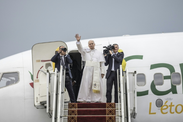 Le pape Léon XIV (au centre) salue ses fidèles alors qu'il monte à bord d'un avion, après avoir célébré la sainte messe à l'aéroport de Bamenda, au Cameroun, le 16 avril 2026 ( AFP / PATRICK MEINHARDT )