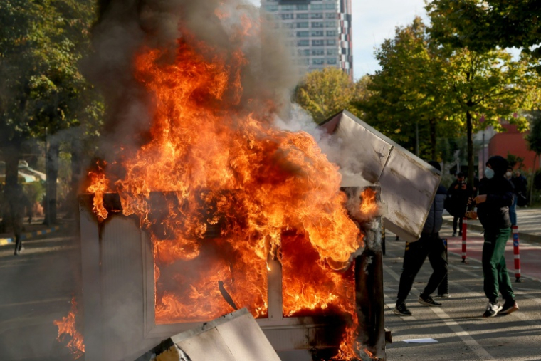 Des manifestants brûlent des cartons lors d'affrontements avec des policiers à Tirana, le 15 octobre 2026 en Albanie ( AFP / Adnan Beci )