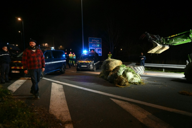 Pierre Guillaume Mercadal (L), leader  de la Coordination rurale de Tarn-et-Garonne (CR 82), participe au blocage de l'A20 près de Montauban, le 18 décembre 2025 ( AFP / Matthieu RONDEL )